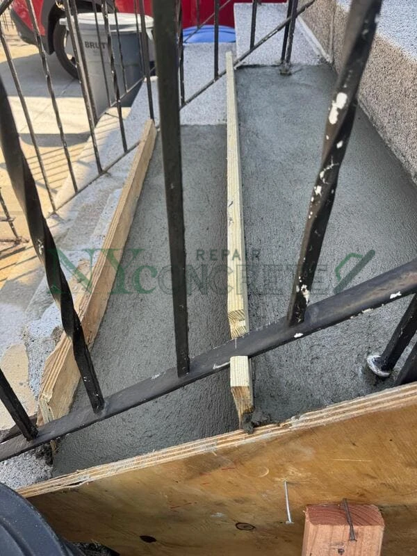 concrete step repair crew working on a nyc brownstone entry