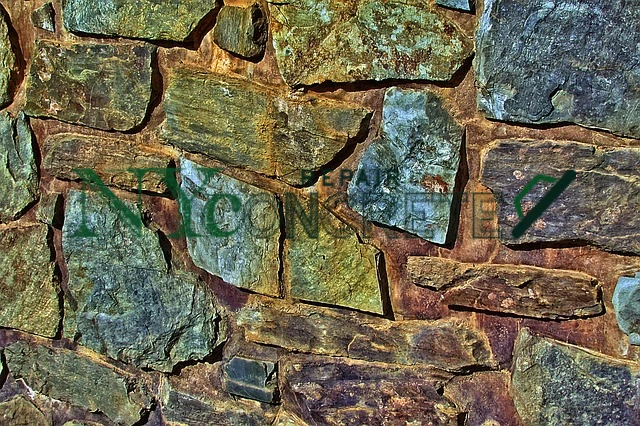 stone masonry contractors repairing a stone wall in nyc